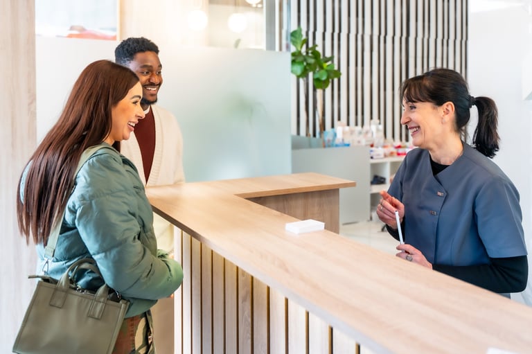 Friendly receptionist helping customers at a modern clinic front desk